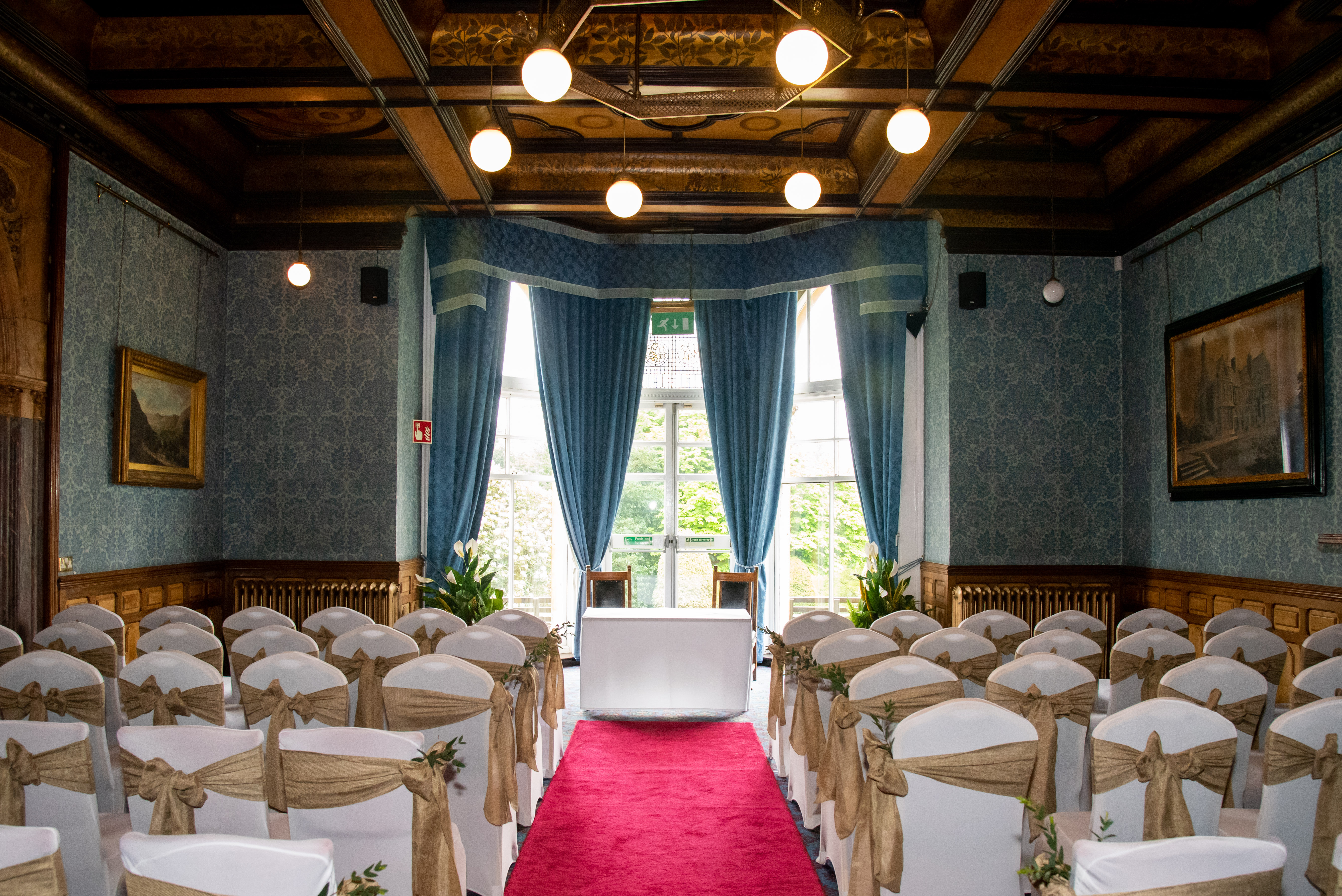Elegant wedding venue with blue walls and white chairs, ideal for formal gatherings.