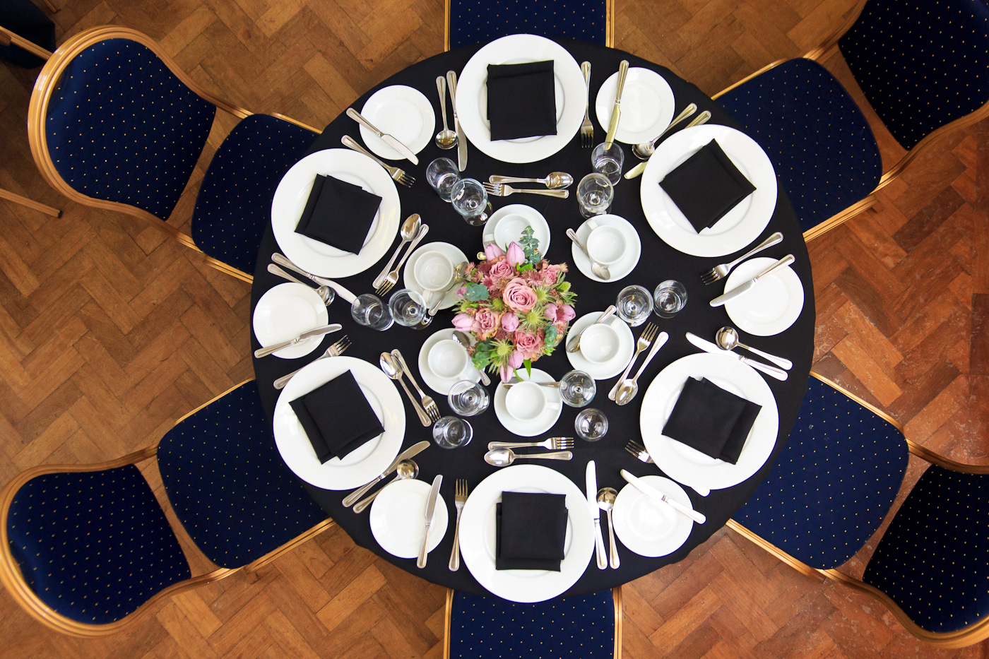 Presidential Suite table set for elegant corporate event with flowers and black napkins.