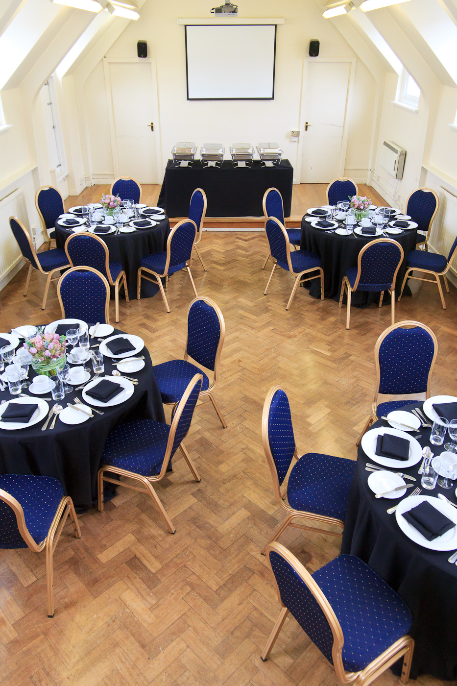 Chapel Suite banquet setup with black linens and blue chairs for formal events.