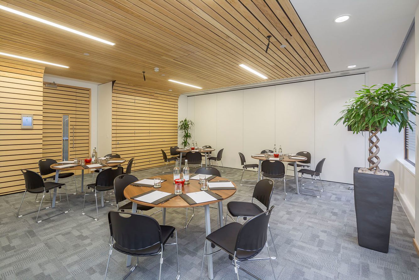 Hindle Room meeting space with round tables, ideal for workshops and brainstorming sessions.