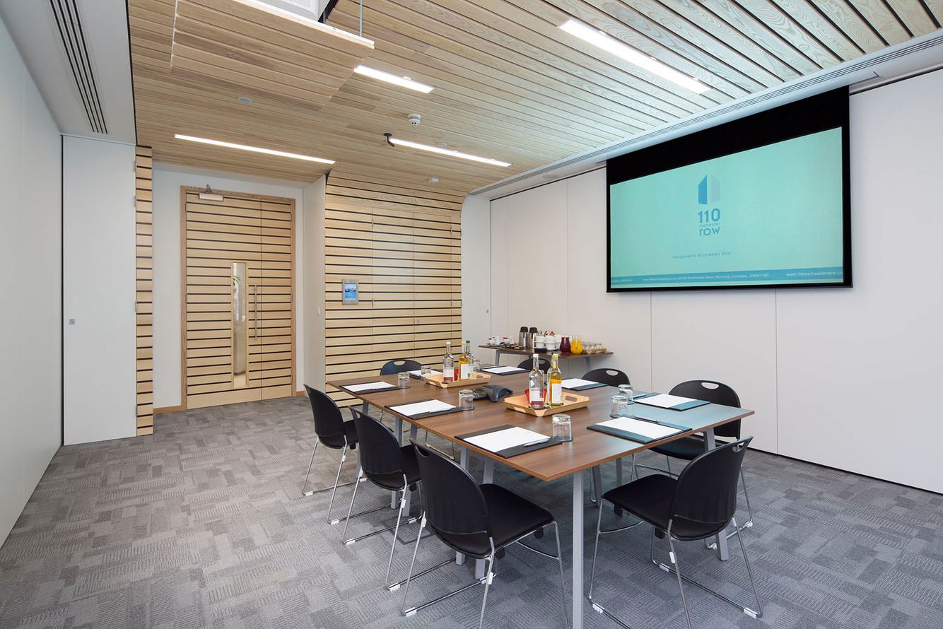 Modern meeting room with wooden paneling, ideal for presentations and collaboration.