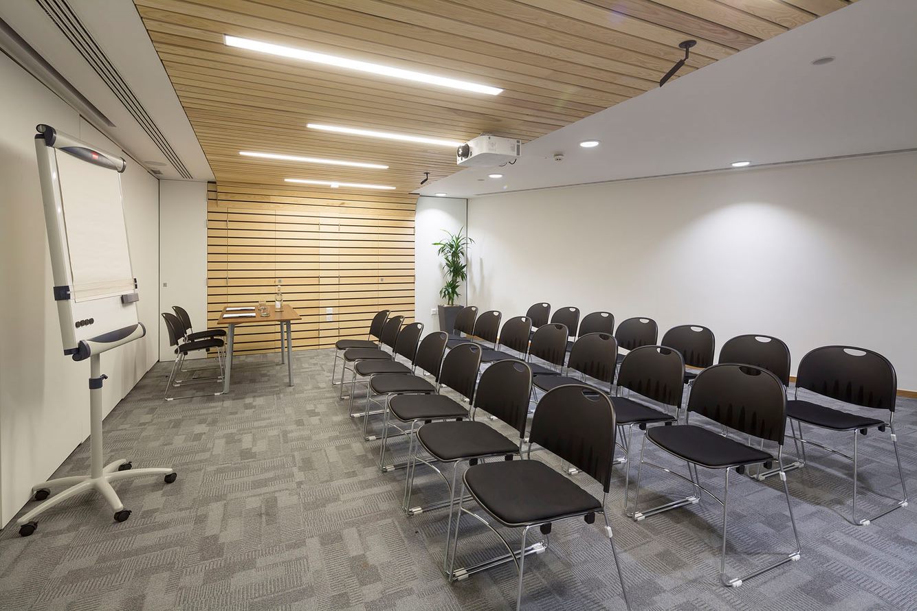 Cavell Room meeting space with black chairs, ideal for workshops and training sessions.