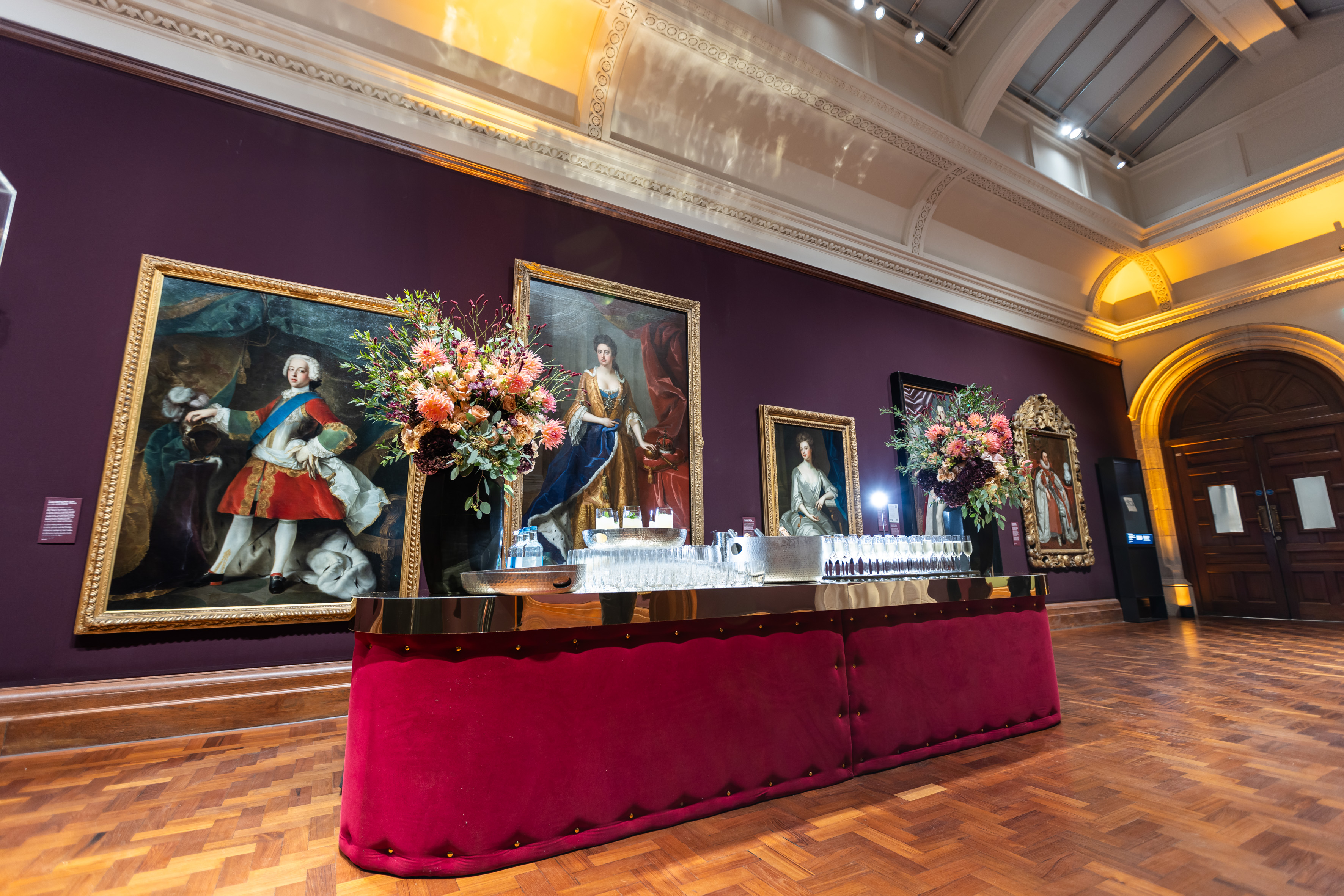 Elegant event setup in National Portrait Gallery with floral bar and classic artwork.
