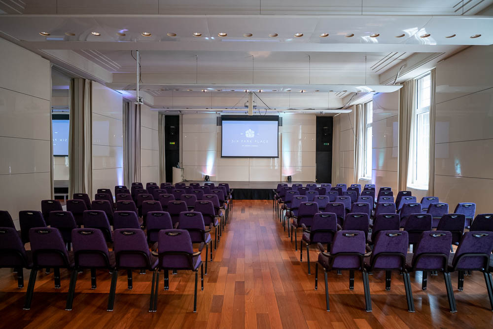 "Princess Alexandra Hall event space with purple chairs, ready for a conference or seminar."