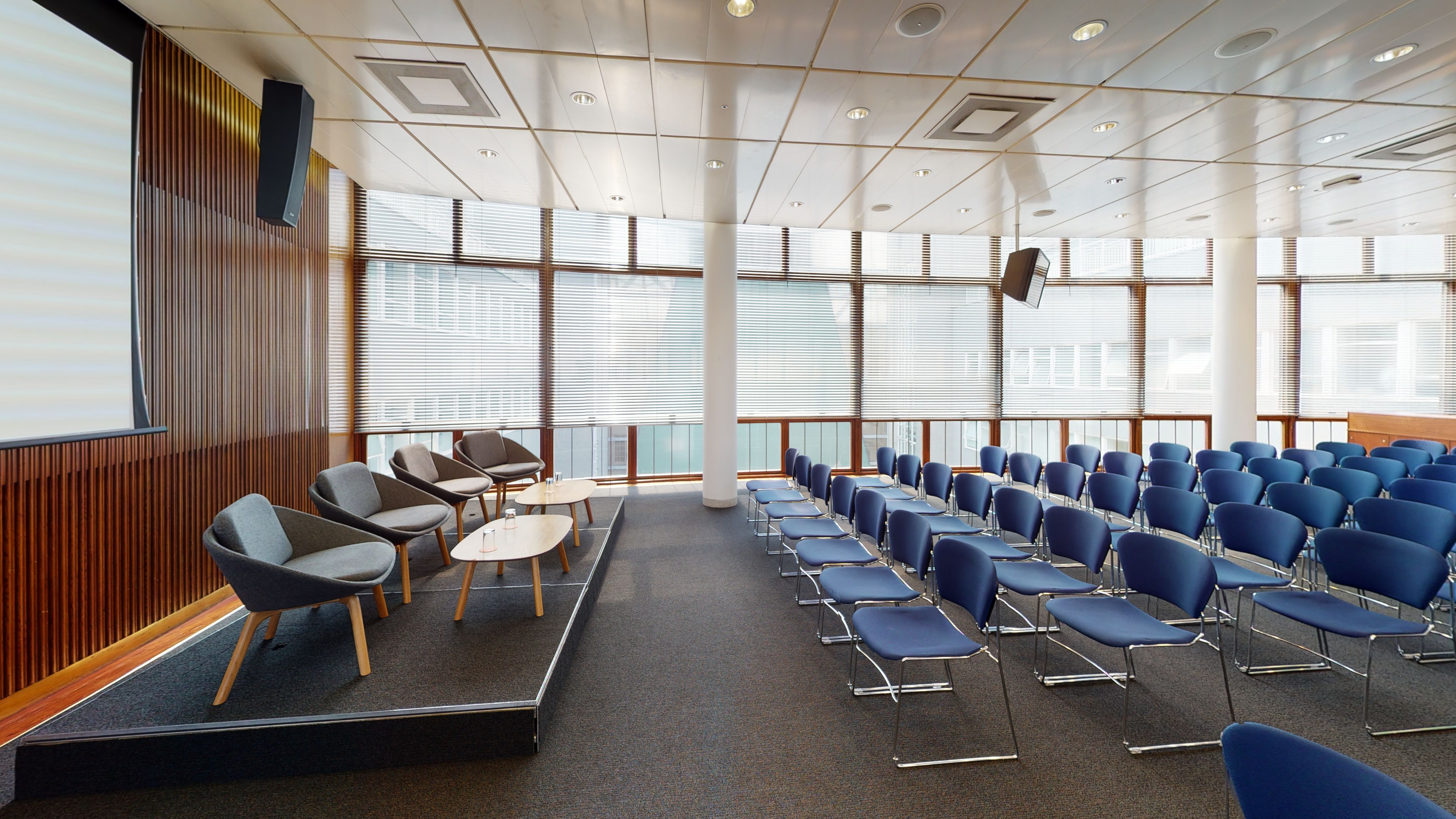 Modern Council Chamber with blue seating, ideal for corporate meetings and workshops.