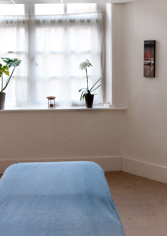 Serene minimalist therapy room with natural light, ideal for workshops and meetings.