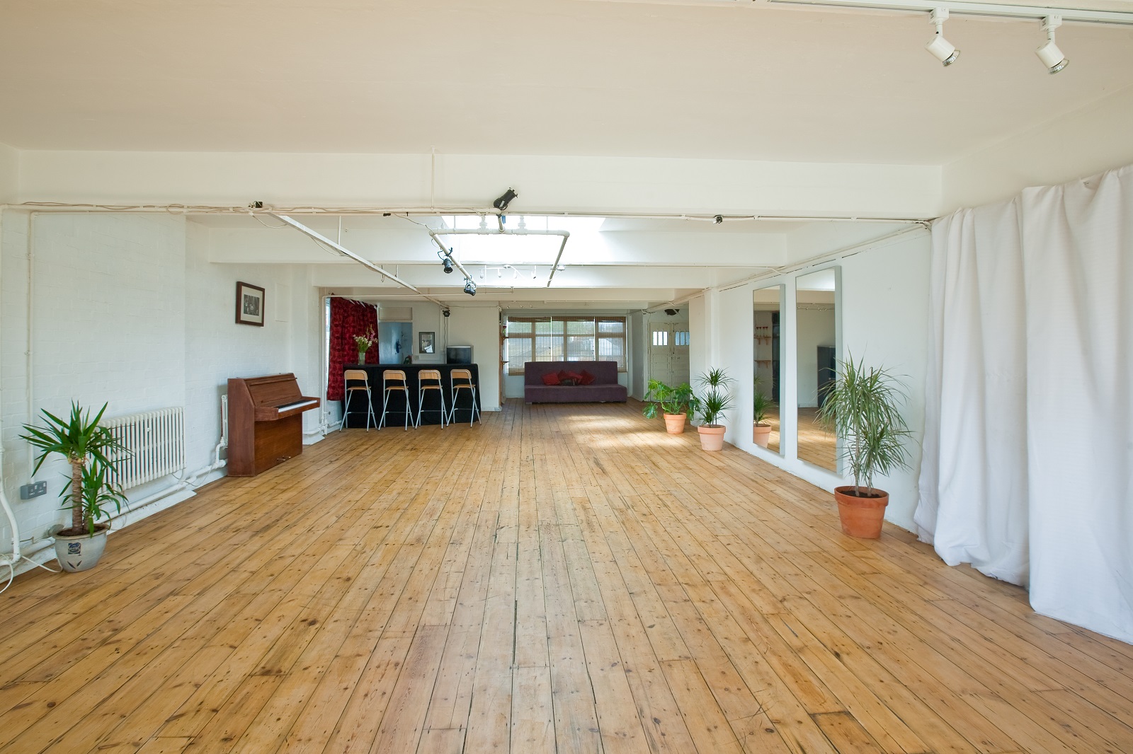Spacious 4th Floor Studios event space with wooden flooring, ideal for meetings and workshops.