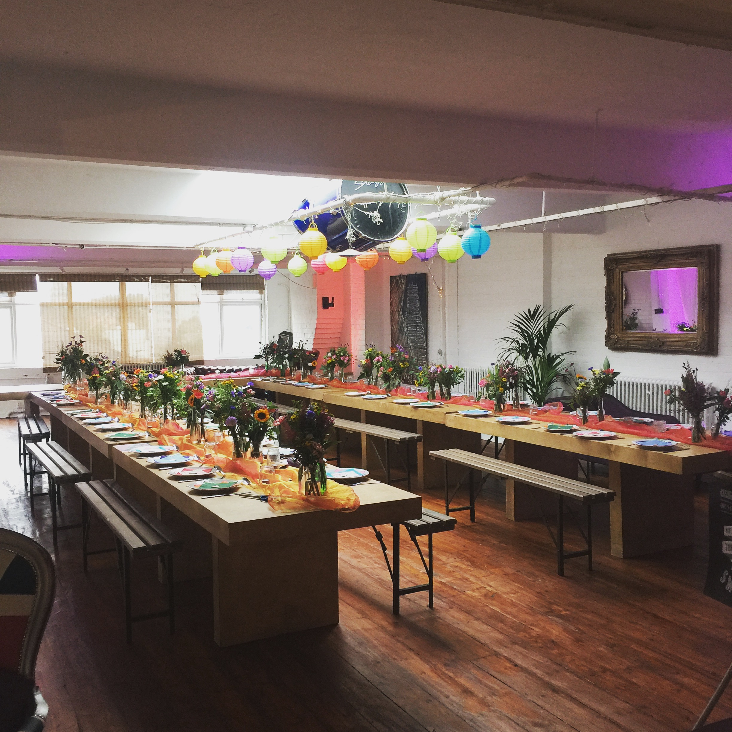 Vibrant event space with long tables and floral centerpieces for gatherings and celebrations.