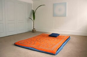 Minimalist workshop room with vibrant cushions for creative gatherings and brainstorming.