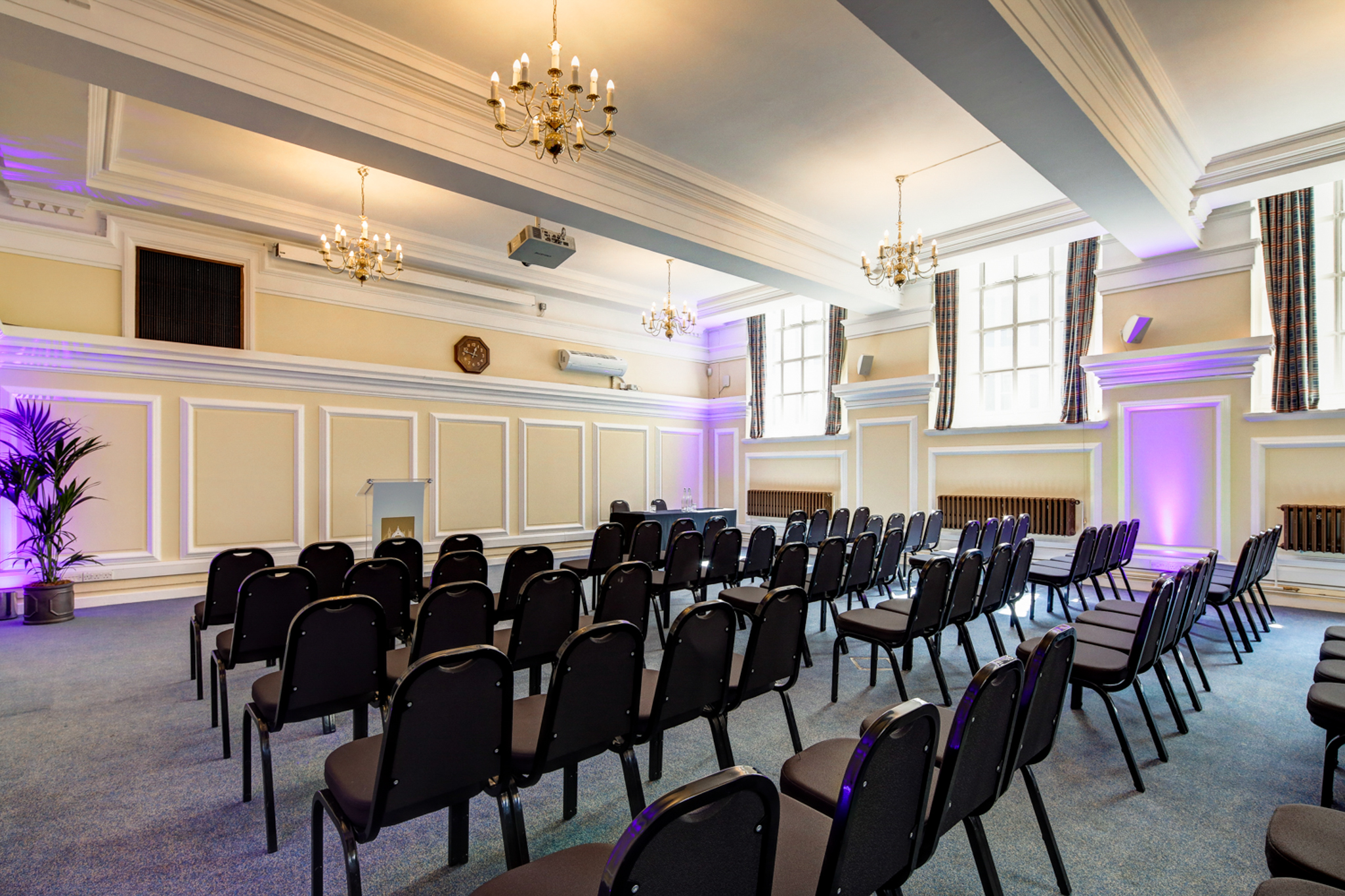 Robert Perks in Central Hall Westminster, elegant conference space with chandeliers and purple lighting.