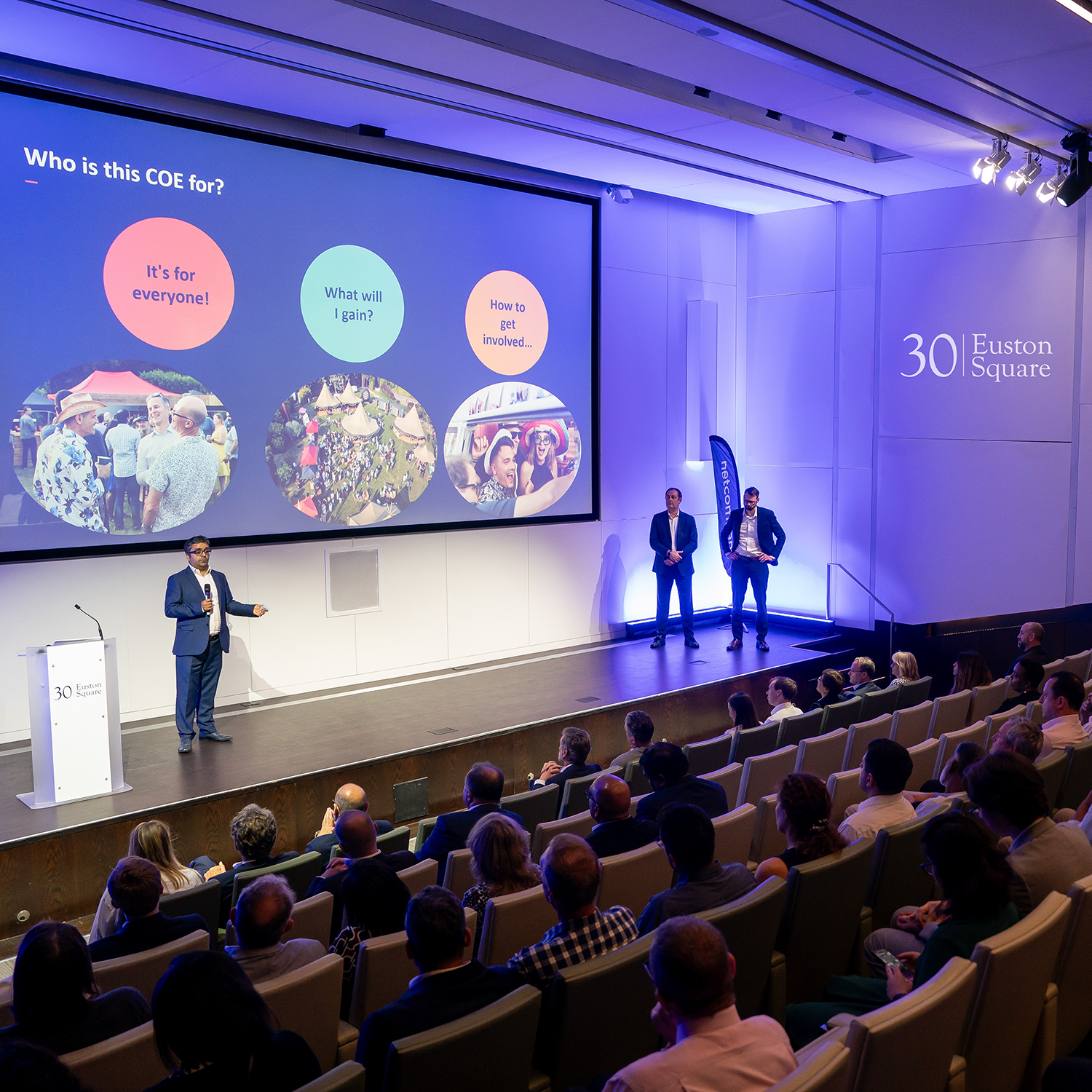 Auditorium at 30 Euston Square with speaker engaging audience in a professional conference.