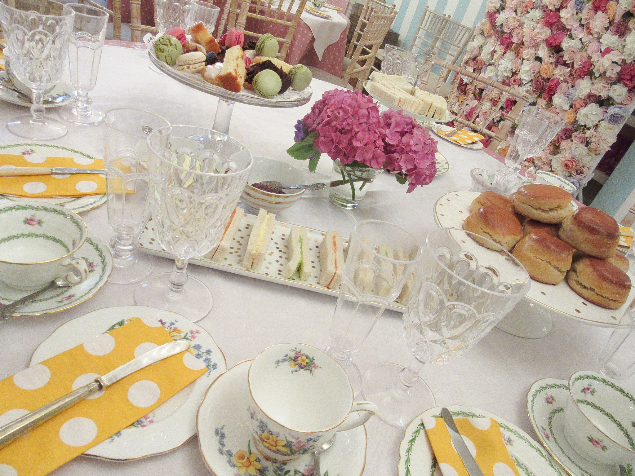 Elegant high tea table setting with floral centerpiece for special occasions.