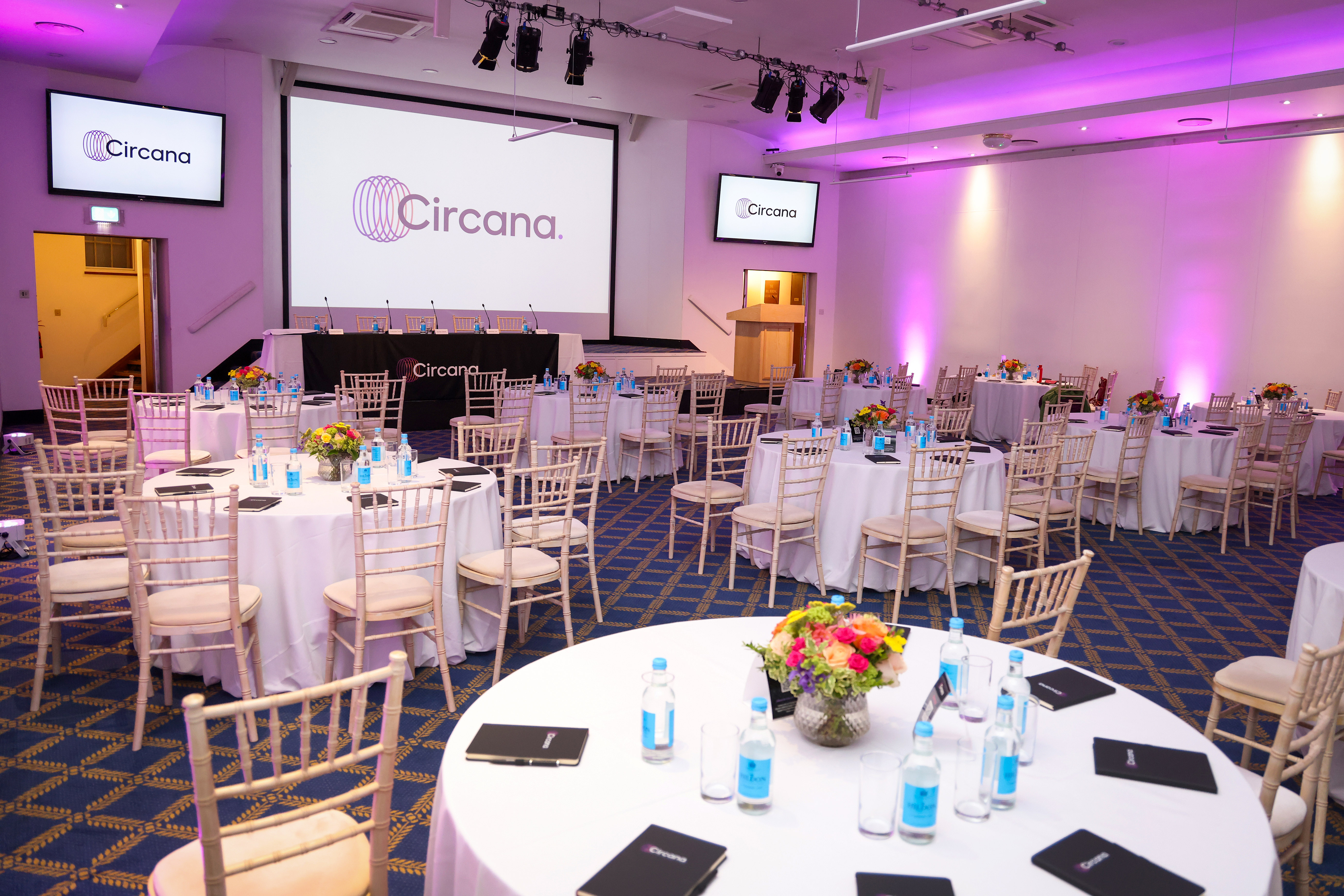 Bill Boeing Room set for corporate meeting with elegant round tables and branding.