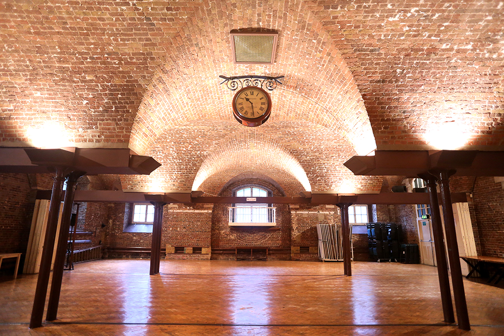 Spacious event venue with exposed brick walls, ideal for meetings and workshops.