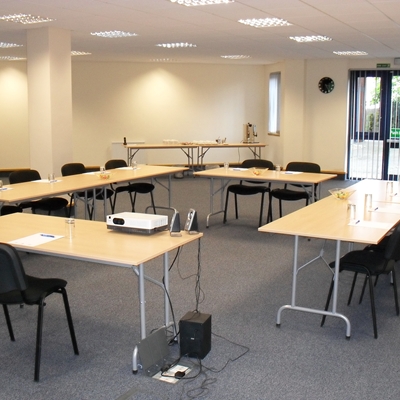 Meeting room setup with U-shaped tables for professional workshops and team meetings.