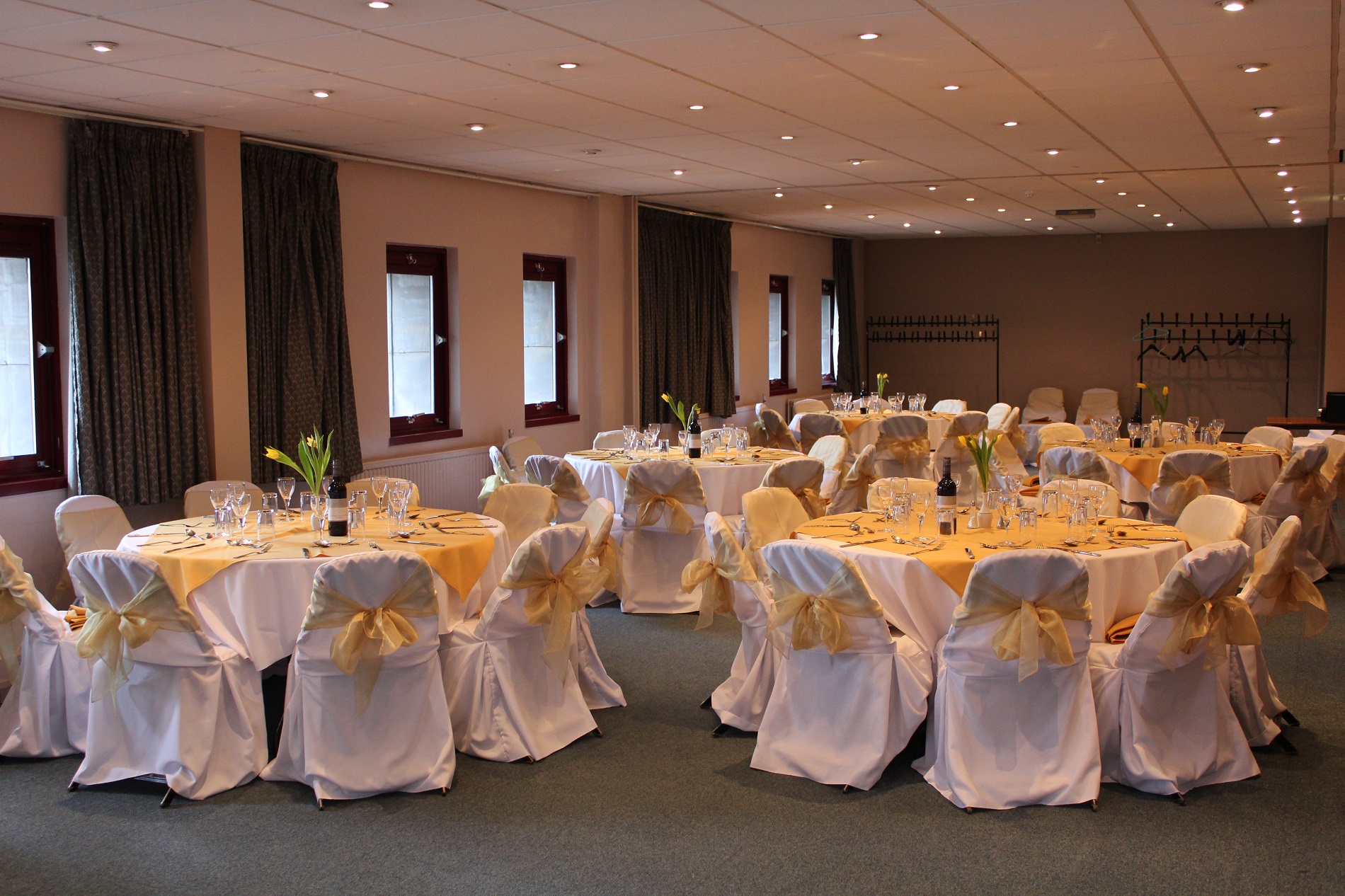 Alexander Wilding Suite with elegant yellow tables, perfect for formal events and celebrations.