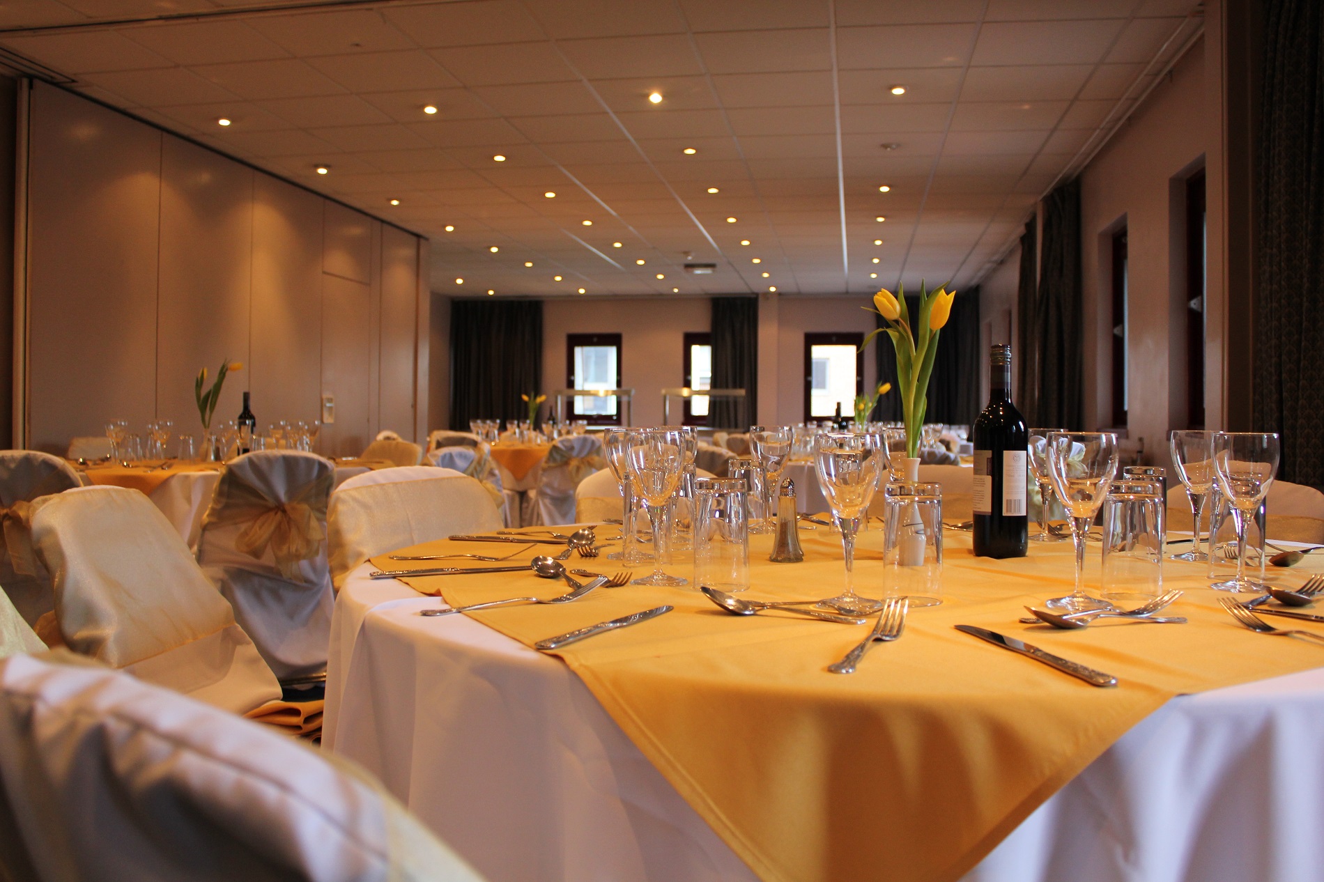 Alexander Wilding Suite banquet room with yellow tablecloths for corporate events.