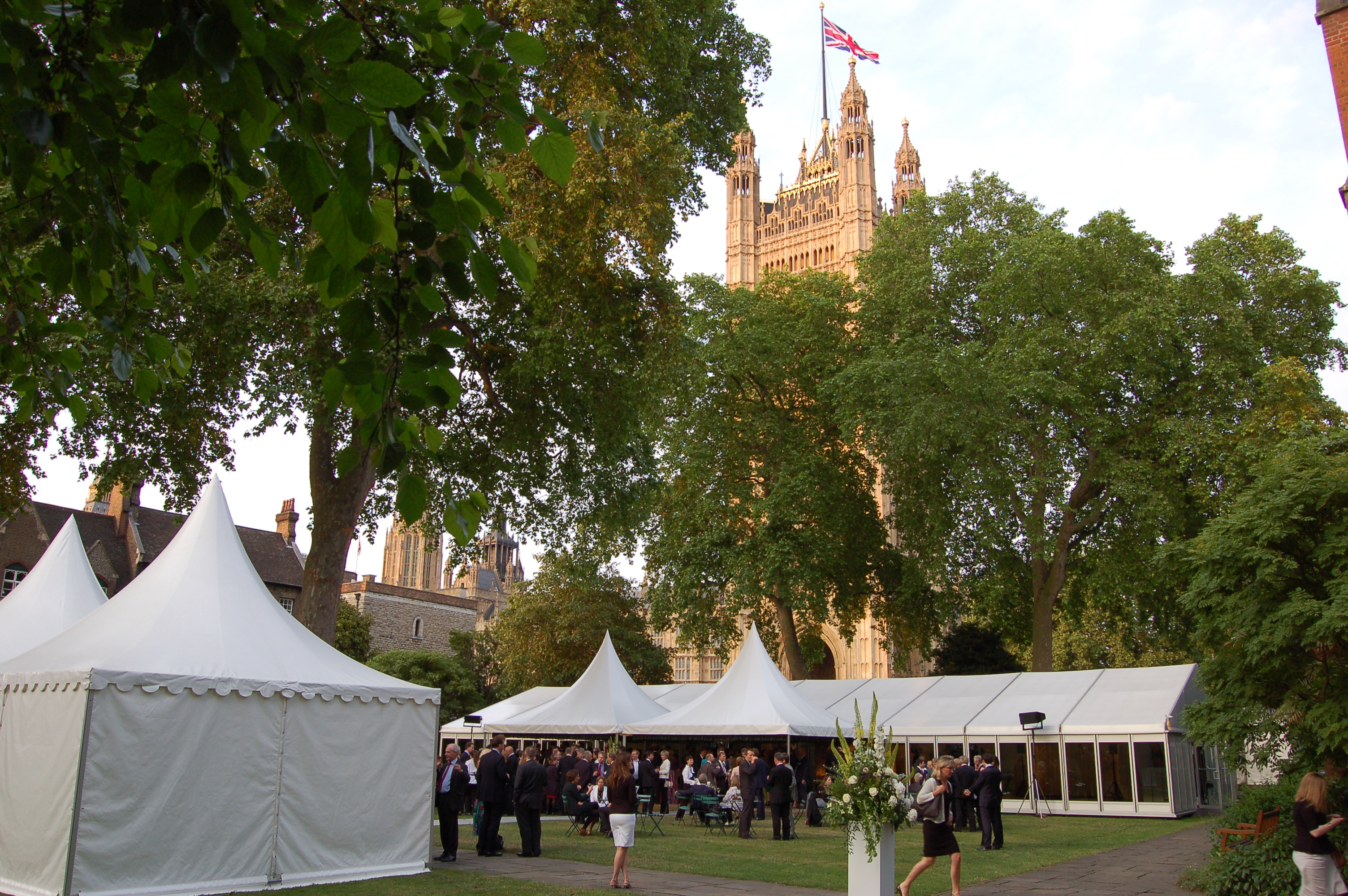 Elegant outdoor event in College Garden, Westminster Abbey with white tents and lush greenery.