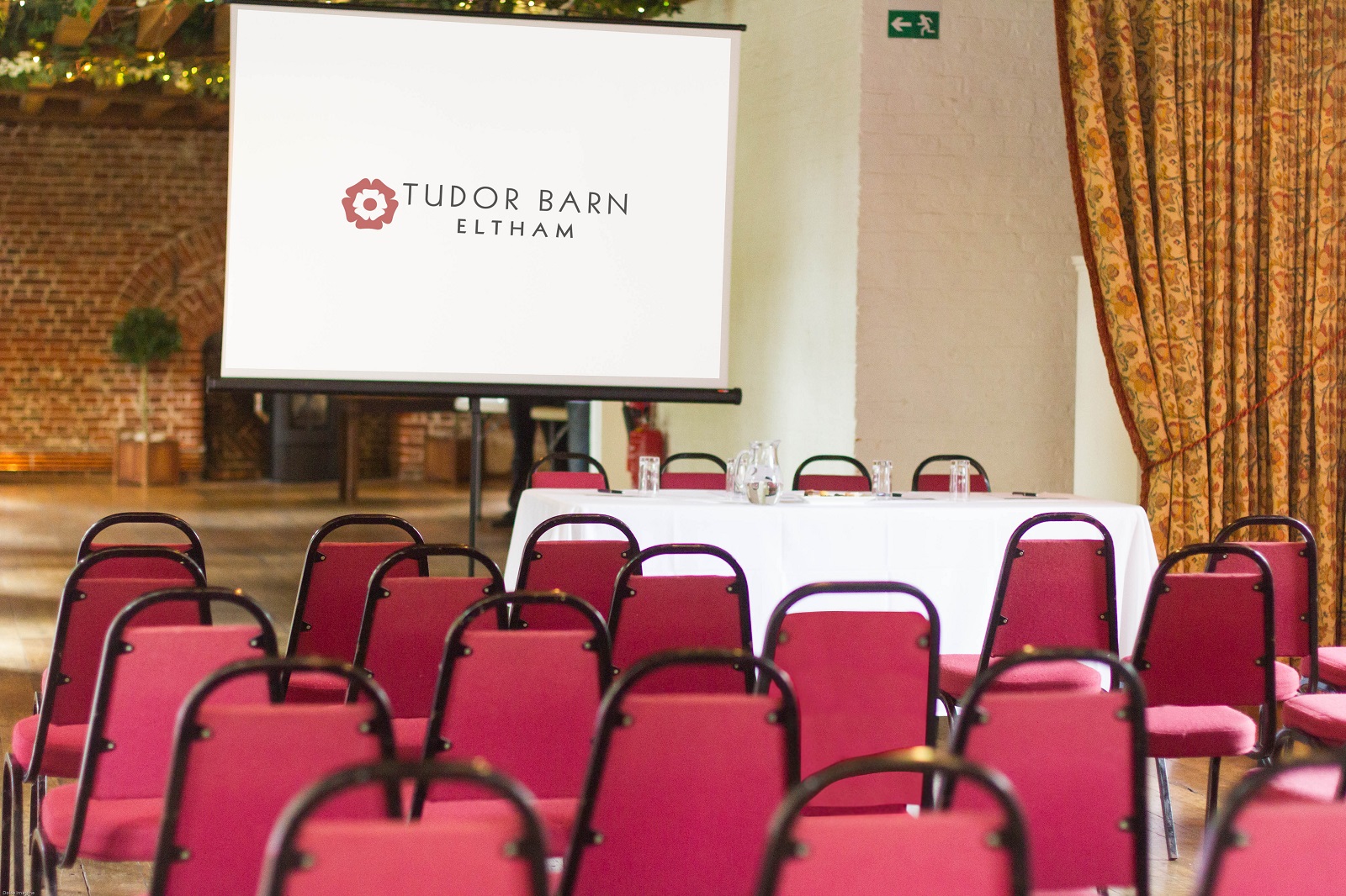 Tudor Barn Eltham meeting space with red chairs, ideal for corporate events and gatherings.