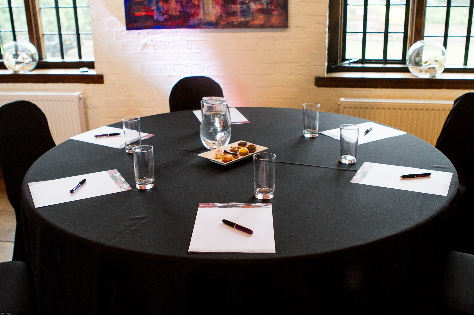 Elegant meeting setup at Tudor Barn Eltham with round table, ideal for conferences and events.