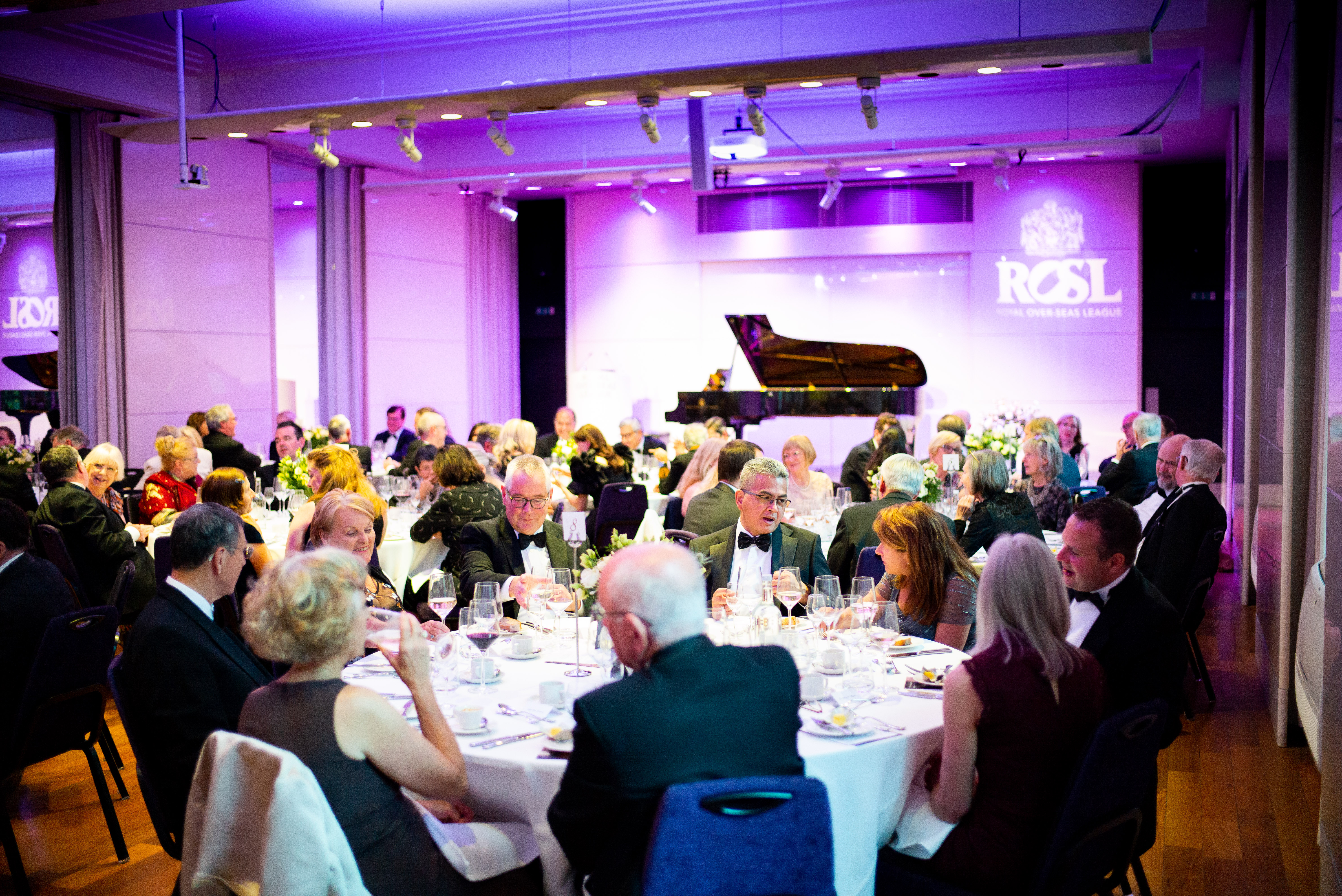 Elegant gala in Princess Alexandra Hall with purple lighting and live piano music.