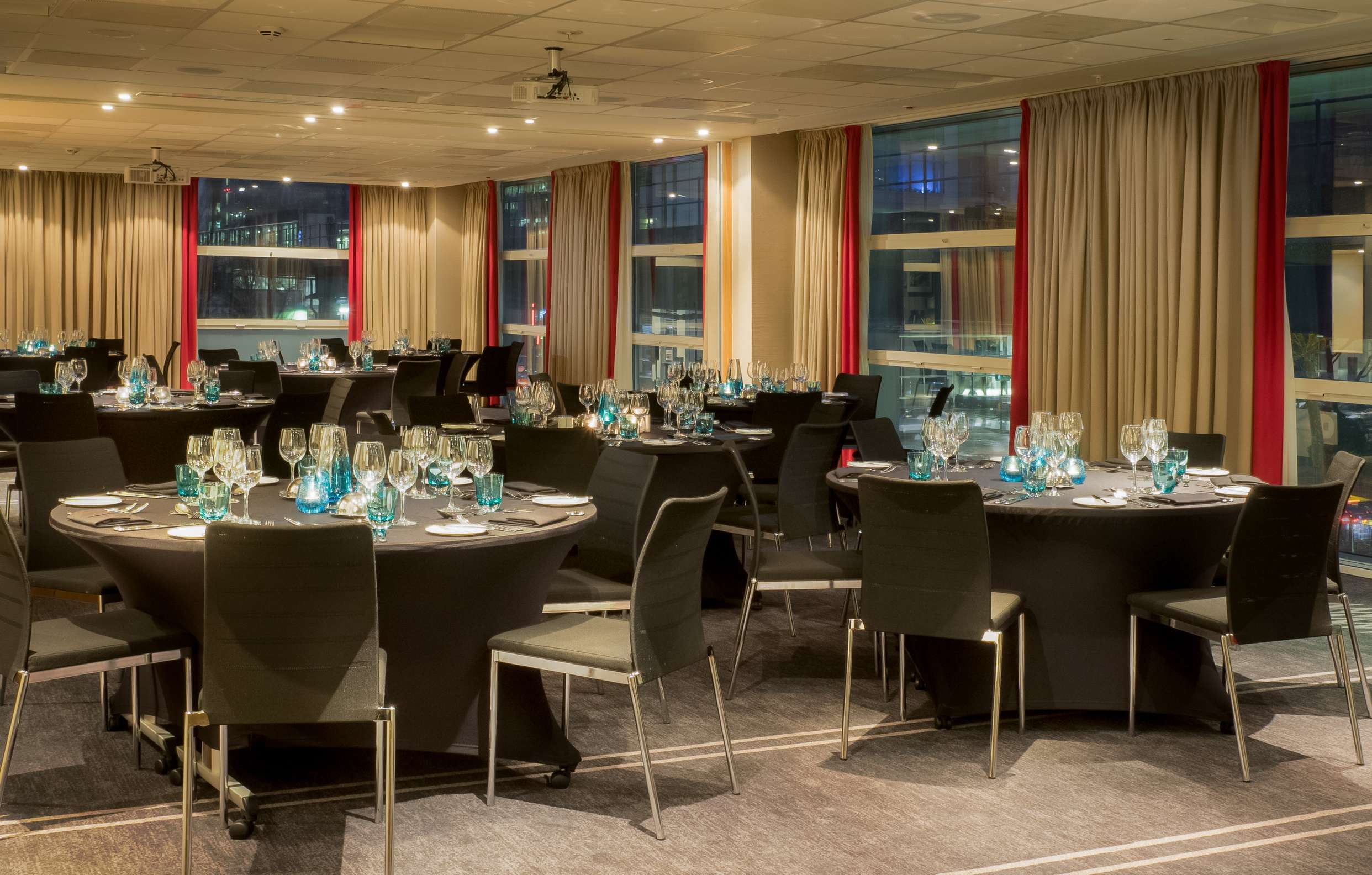 Elegant meeting room set for formal dinner at Hilton London Canary Wharf, ideal for events.