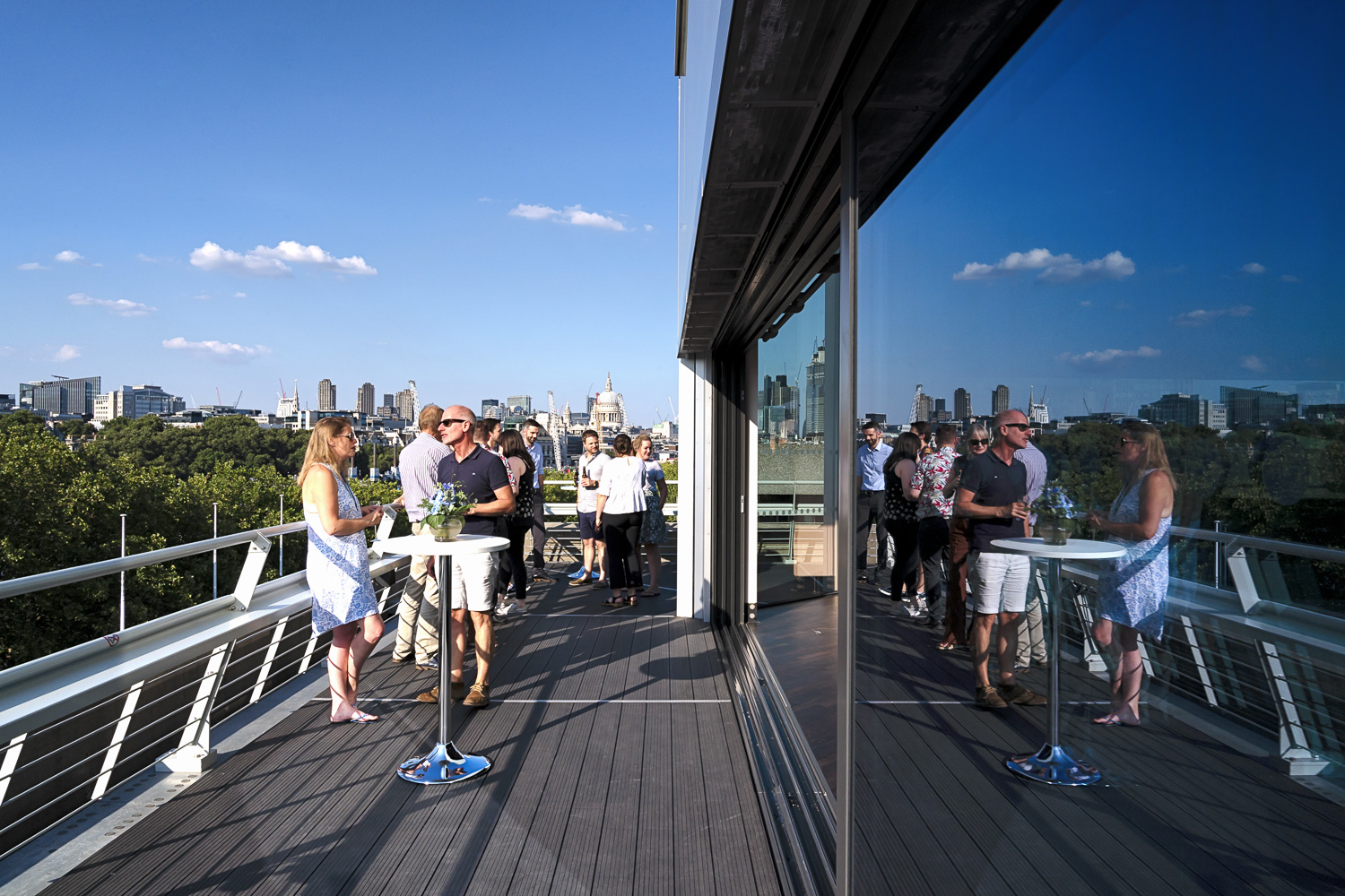 Vibrant outdoor networking event on Buffini Chao Deck with city skyline backdrop.