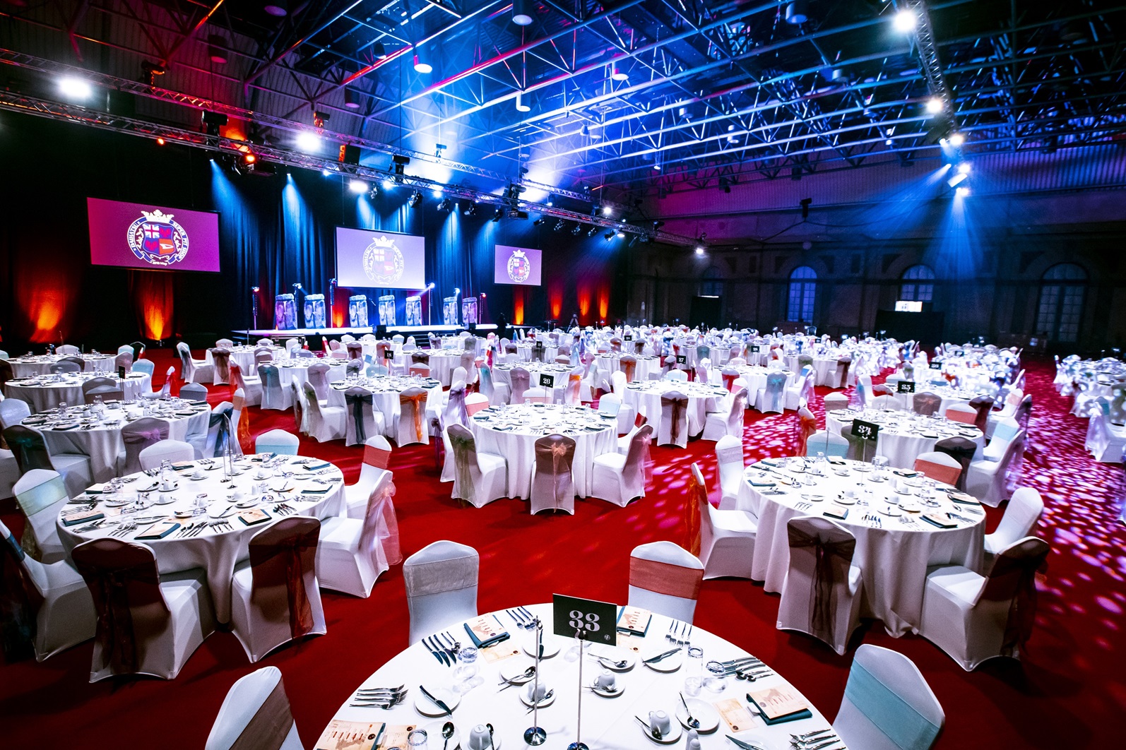 West Hall at Alexandra Palace set for a formal dinner with elegant tables and stage.