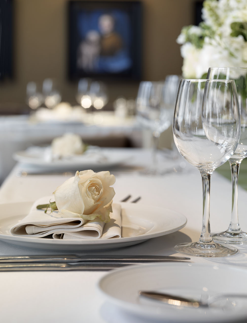 Elegant dining table with white rose at Albert's Club Room for upscale events.