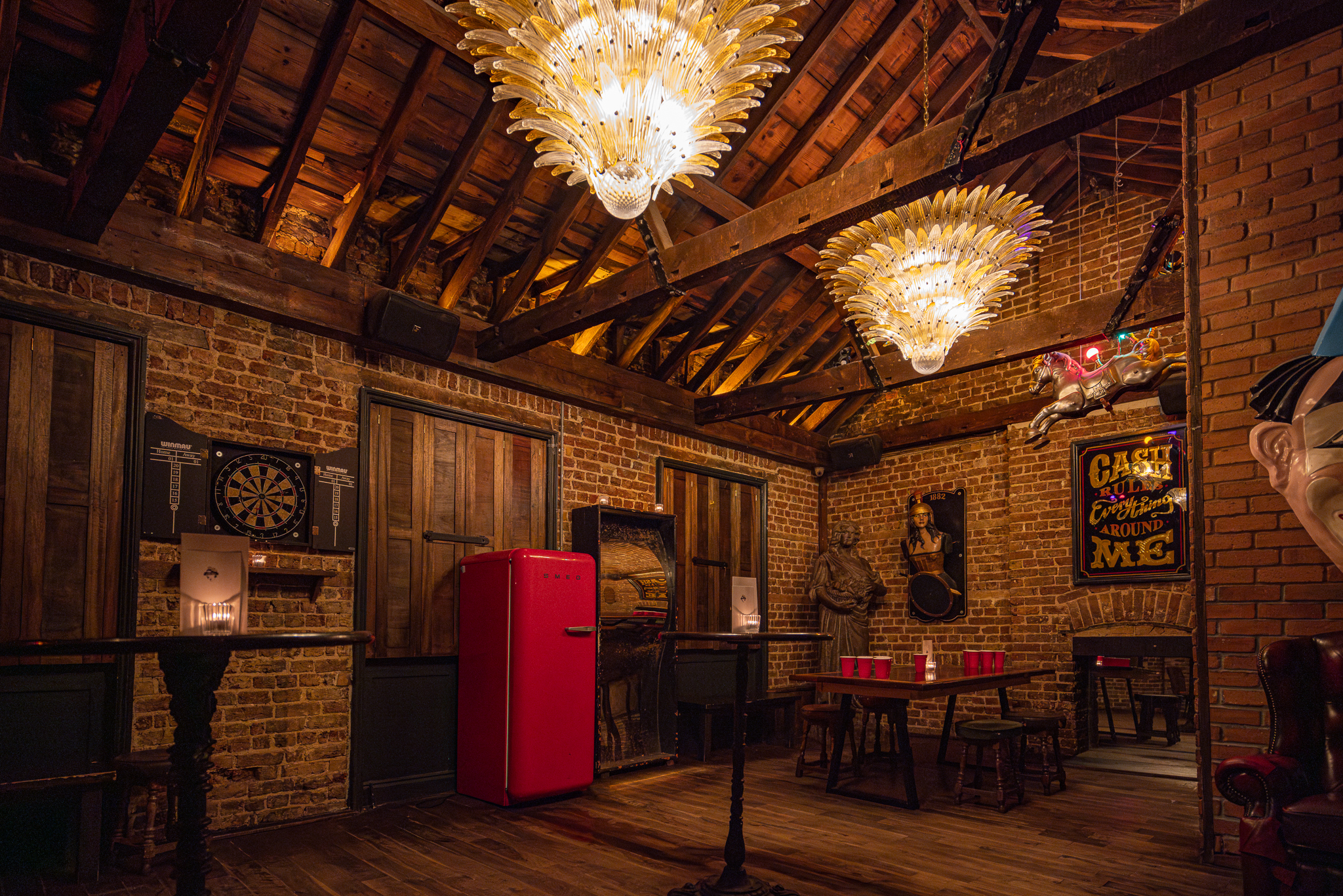The Playroom at The Old Queen's Head, rustic event space with exposed brick walls.