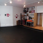 Versatile rehearsal space with black floor, ideal for workshops and small gatherings.