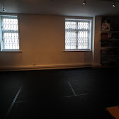 Minimalist rehearsal space with natural light for versatile workshops and meetings.
