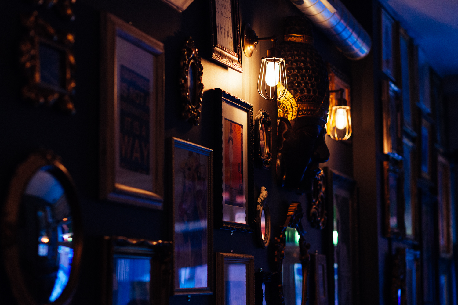 Stylish lounge bar wall with eclectic art, ideal for intimate gatherings and networking events.