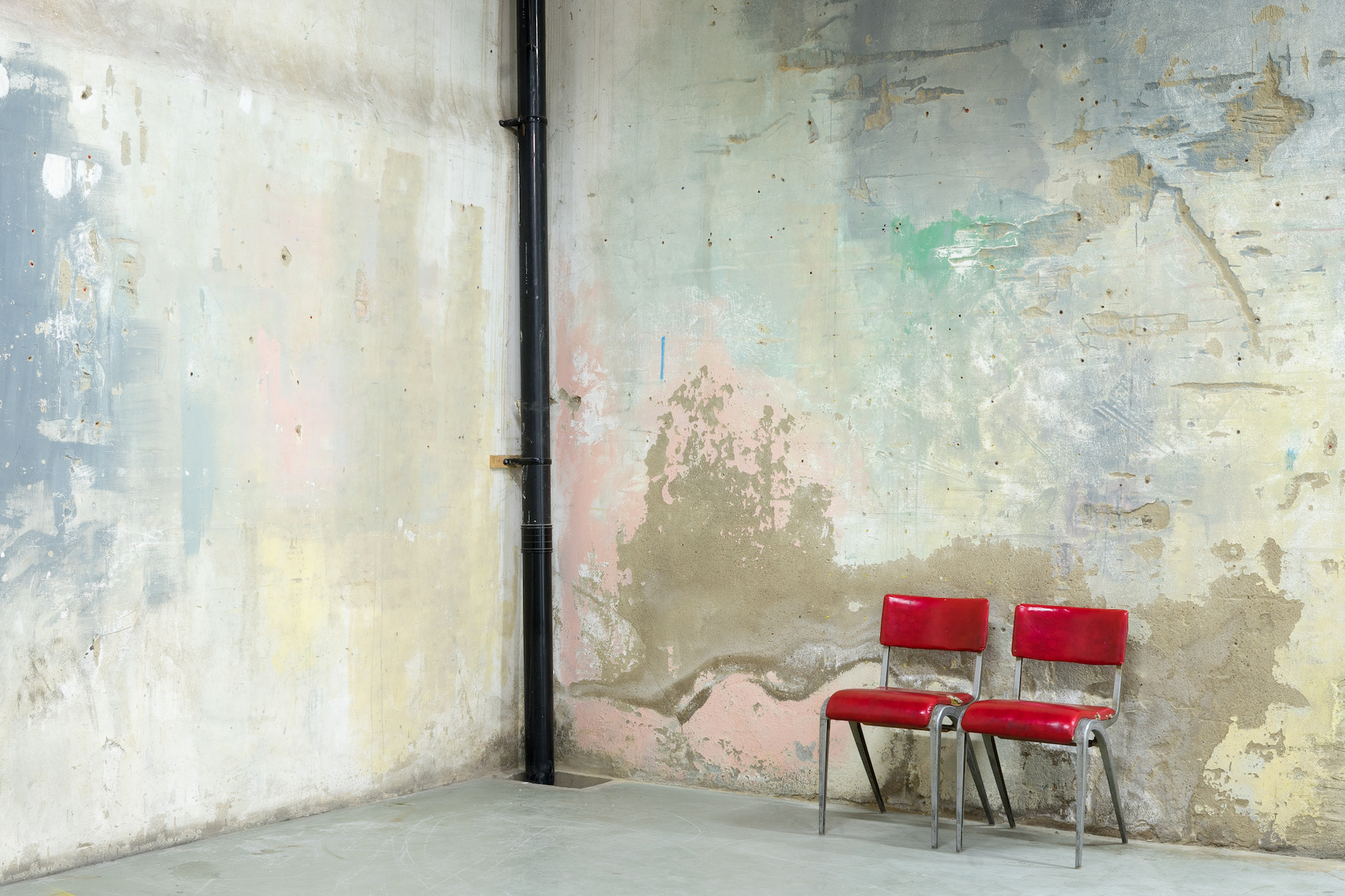 Minimalist meeting space with red chairs, ideal for workshops and brainstorming sessions.