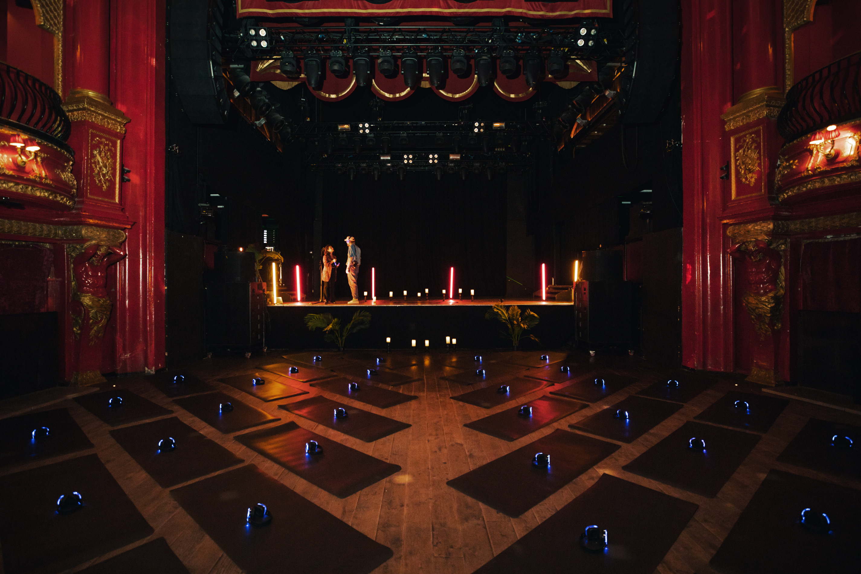 Elegant KOKO venue set for a wellness yoga session with inviting stage lighting.