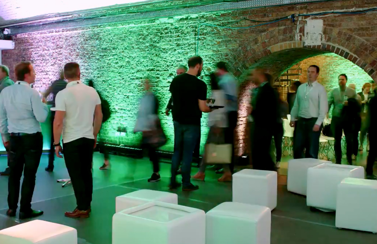 Vibrant event space in Shoreditch Studios with green lighting for networking and collaboration.