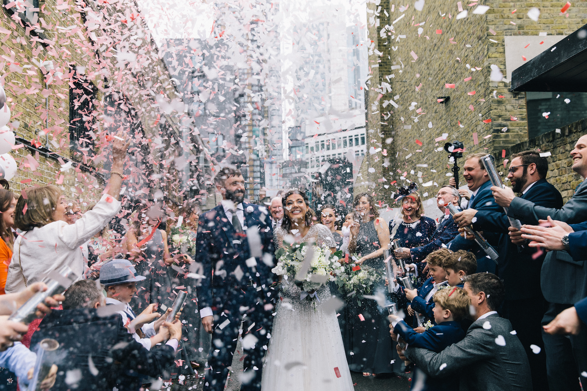 Vibrant wedding celebration at Shoreditch Studios with confetti and urban backdrop.