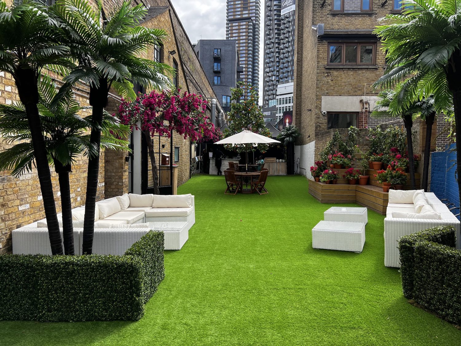 Stylish outdoor event space with artificial grass and modern furniture in Shoreditch Studios.