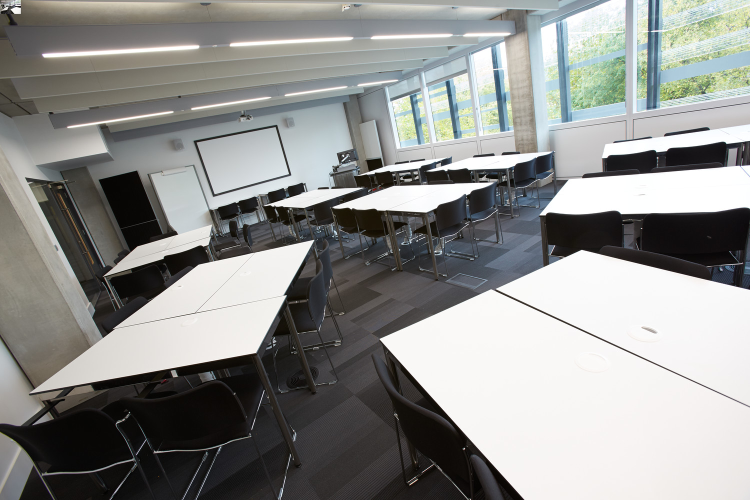 Versatile meeting room with modular tables and natural light for workshops and training.