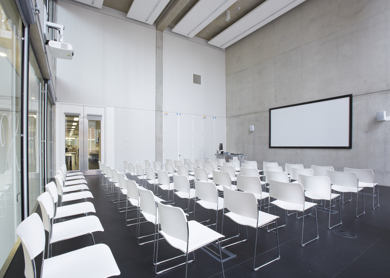 Modern meeting space in Benzie Building with white chairs for workshops and presentations.