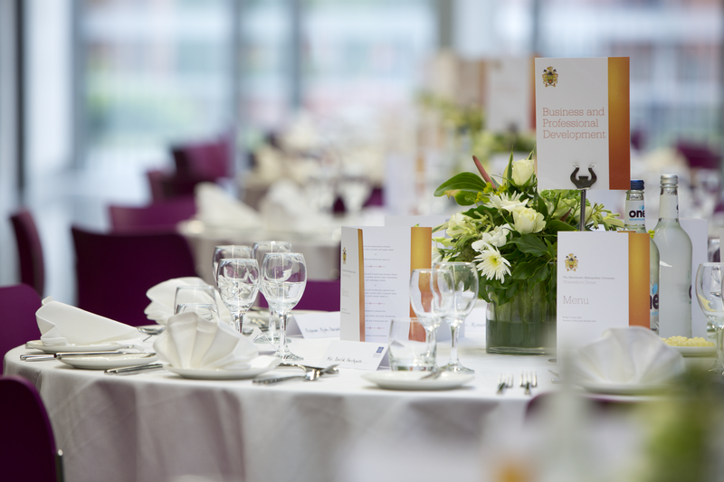 Elegant banquet setup in Business School Atrium with floral centerpieces for events.