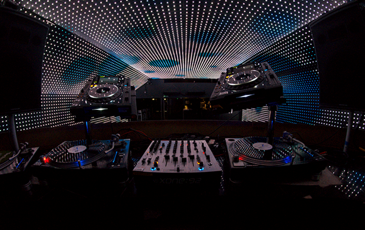 Dynamic DJ setup with turntables and LED lights at Vauxhall Arches event.