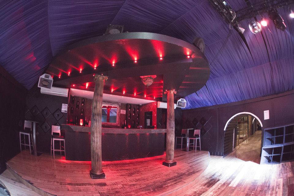Stylish Vauxhall Arches event space with circular bar and red lighting for cocktail parties.