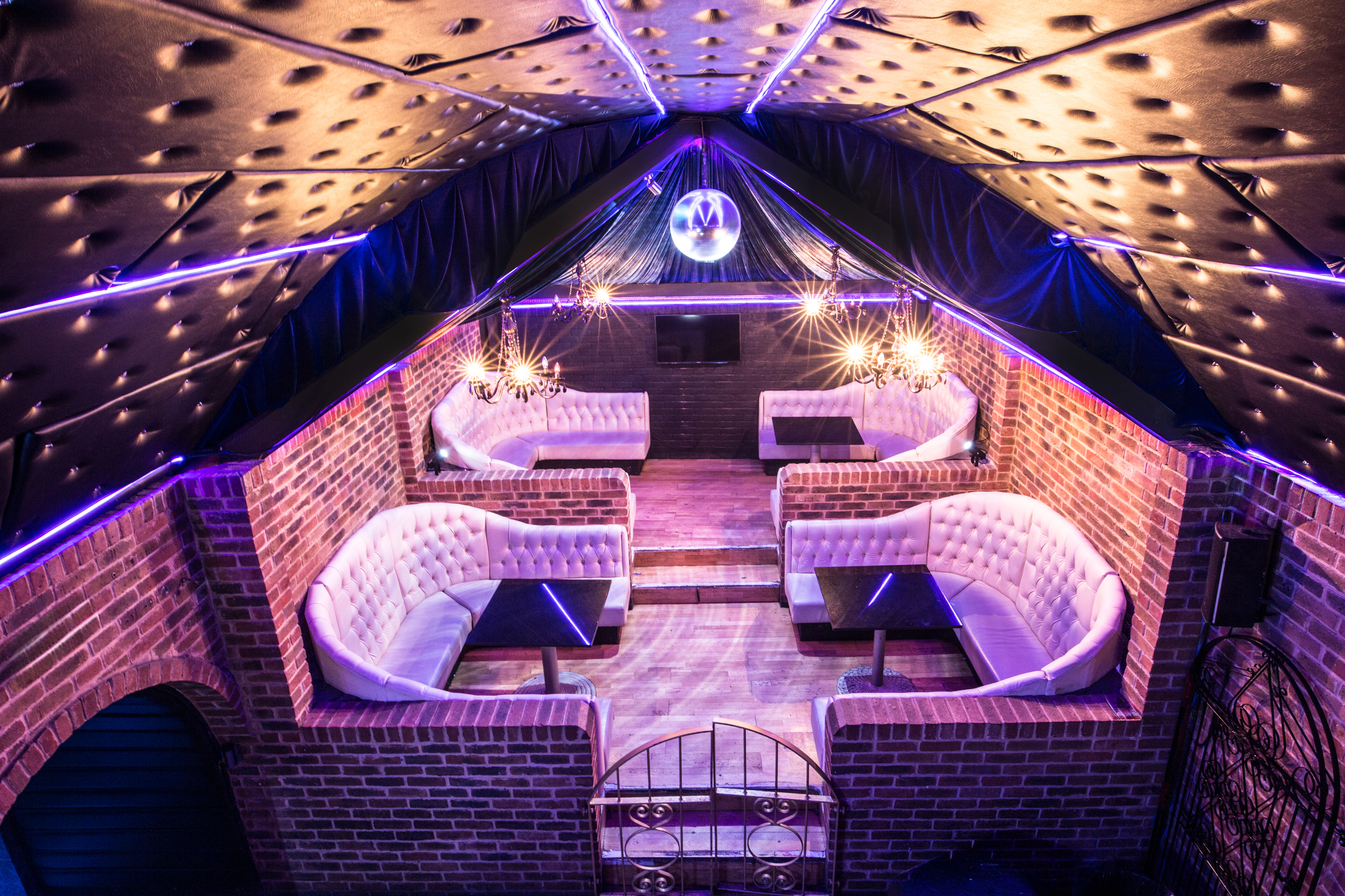 Stylish event space with plush seating and disco ball, perfect for parties and networking.
