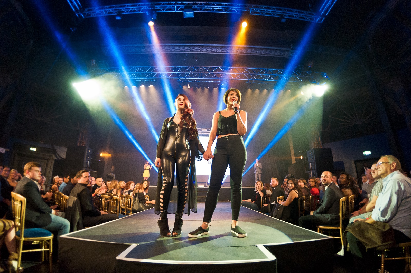 Fashion runway event at Electric Brixton with vibrant lighting and engaged audience.