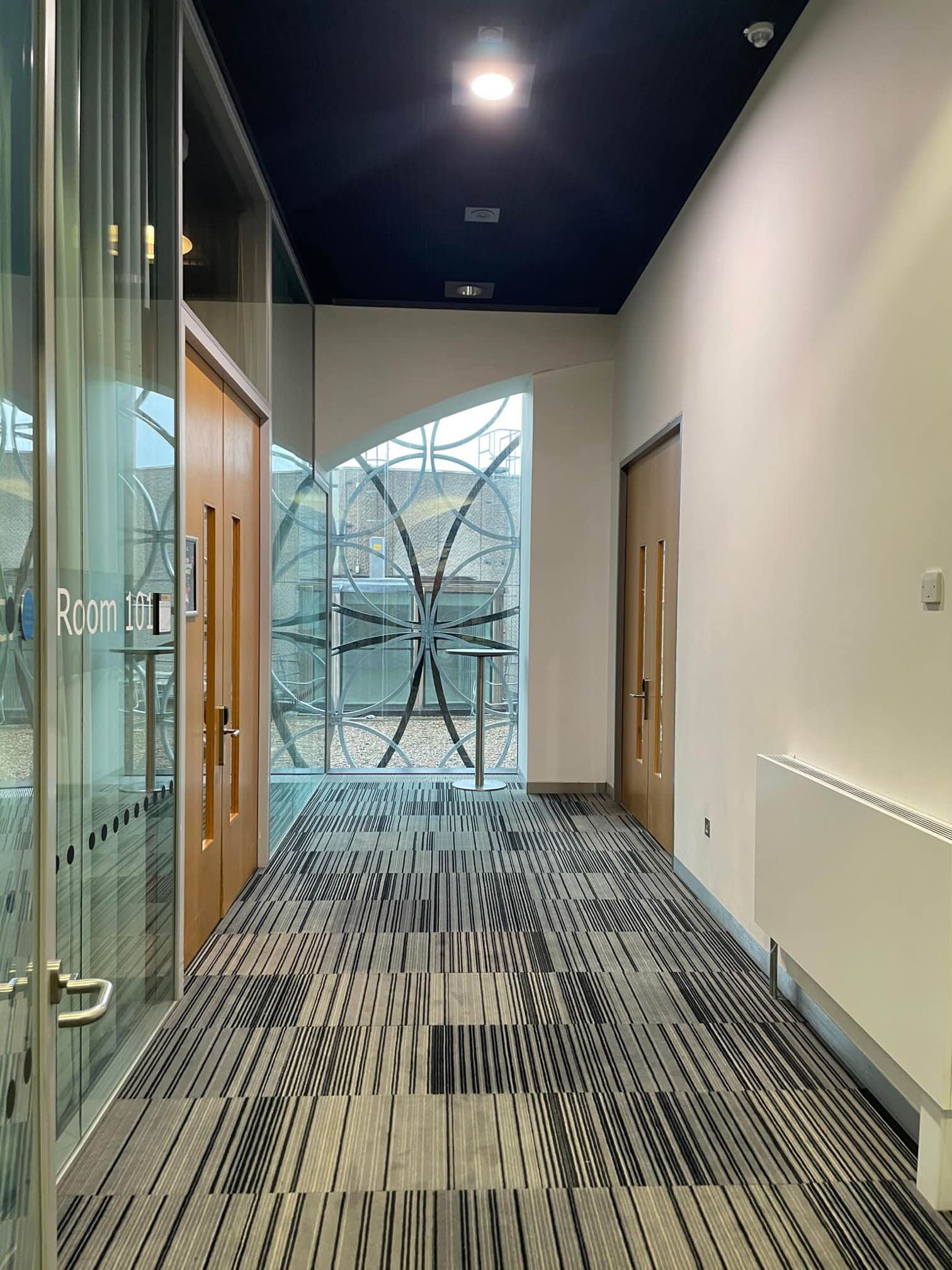 Modern corridor with glass doors at Unique Venues Birmingham for networking events.