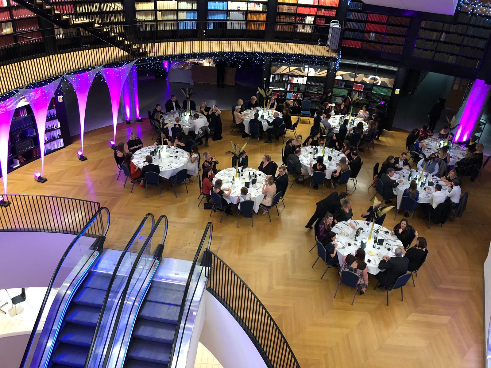 Elegant event space in Book Rotunda, Birmingham with round tables and purple lighting.