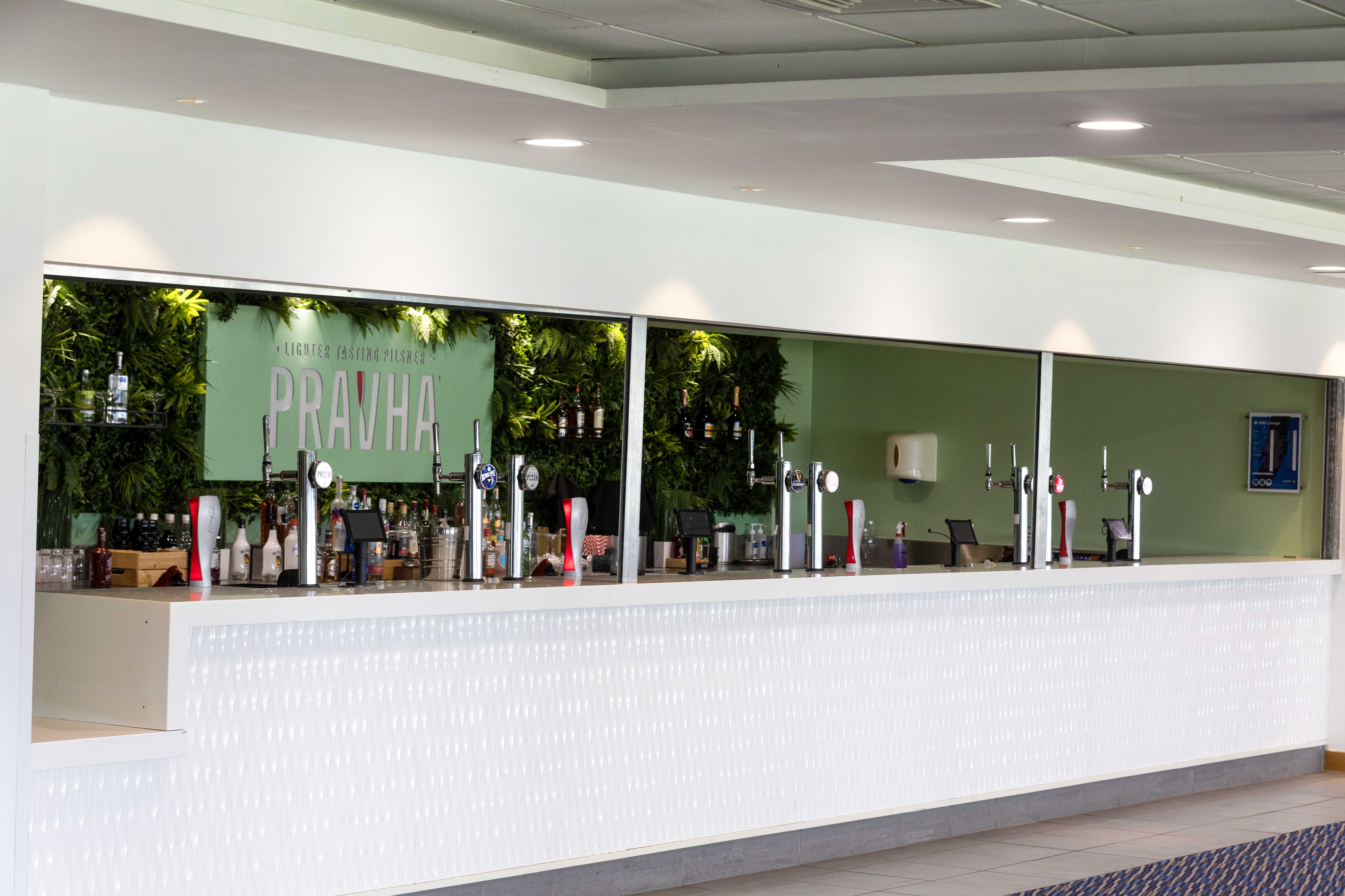 1882 Suite bar at Edgbaston Stadium with green feature wall for corporate events and conferences.