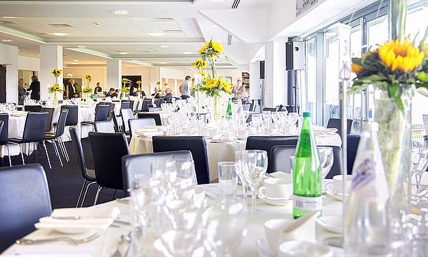Elegant 1882 Suite at Edgbaston Stadium, set for formal networking events with sunflowers.