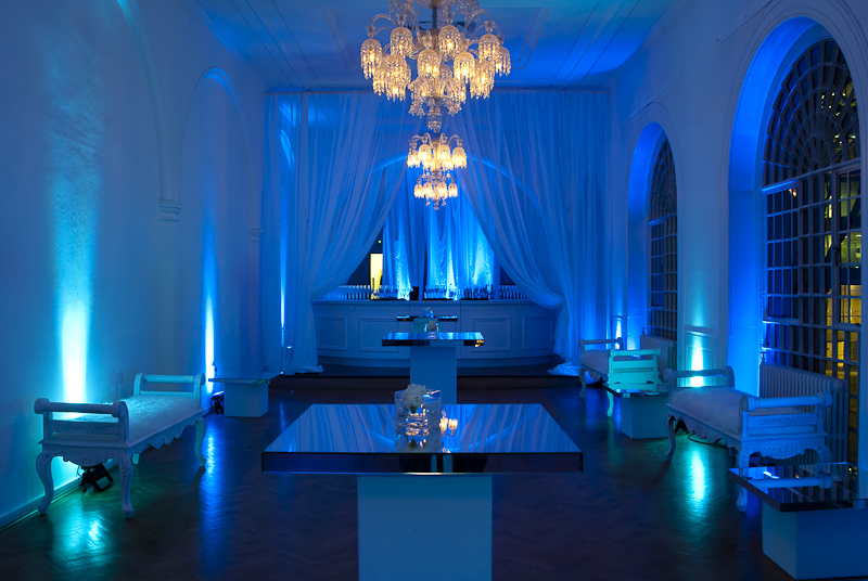 Elegant event space at One Marylebone with blue lighting and luxurious chandeliers.